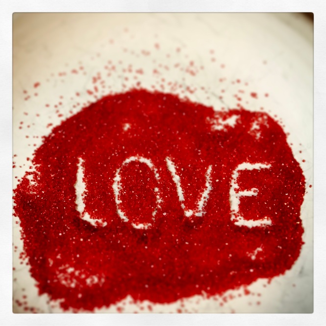 White letters spell out "LOVE" is a mound of red sprinkles.